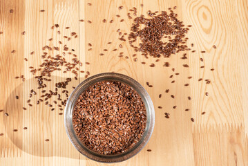Bowl with raw organic flax seeds on wooden table