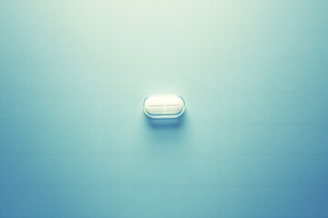 Pill on blue background, medicine concept