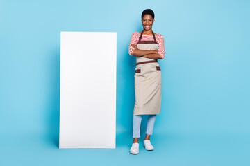 Full length photo of young girl guy folded hands shopkeeper salesperson board poster isolated over blue color background