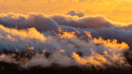 Naklejka premium Tranquil view of the amazing sunrise through the clouds over Haleakala volcano summit at Haleakala National Park on the island of Maui, Hawaii, USA 