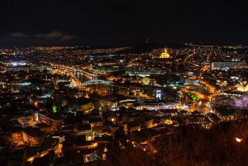 View across the city of Tbilisi, Georgia at night.. Aerial drone night photo of Tbilisi. Mother of Georgia in Sololaki hill Georgia.Night view of old town in Tbilisi