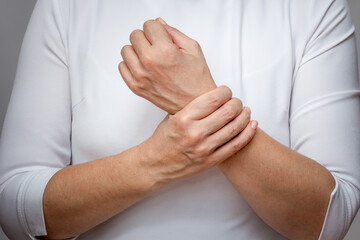 Woman hands showing wrist pain over cropped body - obrazy, fototapety, plakaty