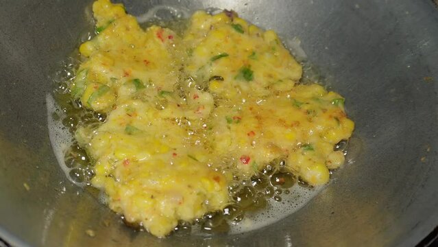 The process of cooking corn cakes by frying until golden brown