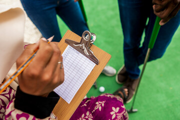 Scoring fun at mini golf with diverse friends