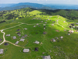 Aerial View of Mountain Cottages on Green Hill of Velika Planina Big Pasture Plateau, Alpine Meadow Landscape, Slovenia - 773971564