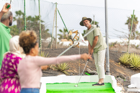 Multicultural Friends Enjoying Mini Golf Outdoors