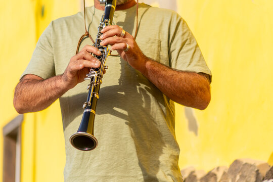 Street musician playing clarinet in sunny town