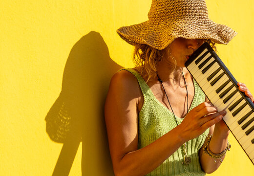 Street Musician Playing Keyboard Against Yellow Wall