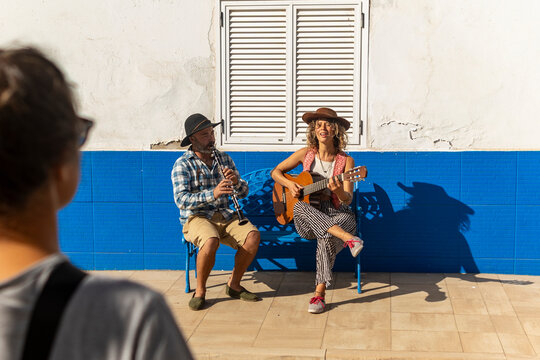 Street musicians performing in a sunny town