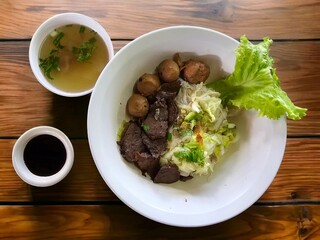 Dry beef noodles with black sauce and clear soup.