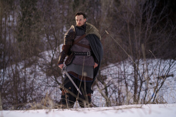 Medieval knight with sword in armor as style Game of Thrones in winter forest - 773975148