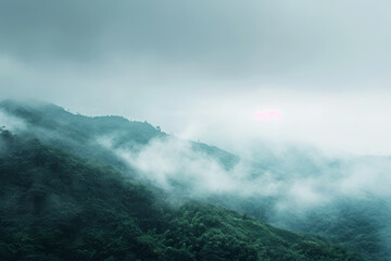 A mountain peak covered in thick fog and clouds on a cloudy day