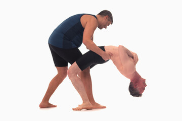 Work with an instructor, Ashtanga yoga  Side view of man and male instructor doing Yoga exercise against white background.