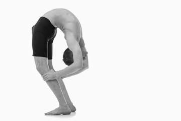Tirieng Mukha Uttanasana (inhale), Ashtanga yoga  Side view of man wearing sportswear doing Yoga exercise against white background. Copy space for text or design.