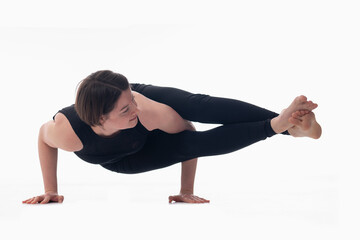 Astavakrasana, Ashtanga yoga  Side view of woman wearing sportswear doing Yoga exercise against white background.
