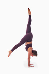 Parivrttasana variation, Ashtanga yoga  Side view of woman wearing sportswear doing Yoga exercise against white background.