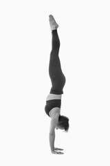 Parivrttasana, Ashtanga yoga  Side view of woman wearing sportswear doing Yoga exercise against white background.  Black and white image.