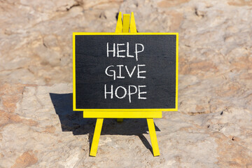 Fototapeta premium Help give hope symbol. Concept word Help give hope on beautiful black chalk blackboard. Red stone. Beautiful red stone background. Business motivational help give hope concept. Copy space.