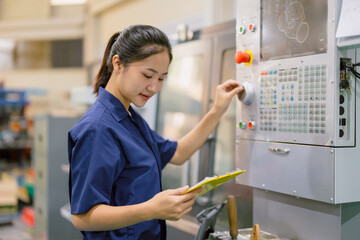 Engineer women control operate CNC industrial machine in metal production workshop. Asian young...