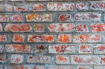 Wall background of bricks with cement filled between them.