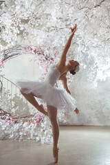 Ballerina in a white stage costume in a fairy-tale hall.
