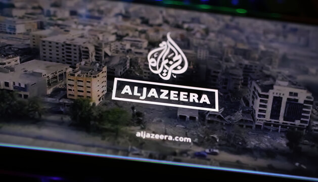 Viersen, Germany - April 1. 2024: Smartphone screen on computer keyboard with logo lettering of Al Jazeera arabic television with Gaza Israel conflict report