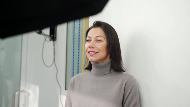 Caucasian woman posing, photographed before modeling the veneers in modern dental clinic with the lighting equipment. Taking photo of female patient before UV whitening procedure. Cosmetic dentistry.