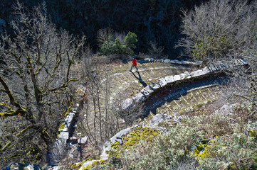 Hiker at the Skala Vitsas, the stone path at the village of Vitsa in Zagori of Epirus, Greece - 774016598