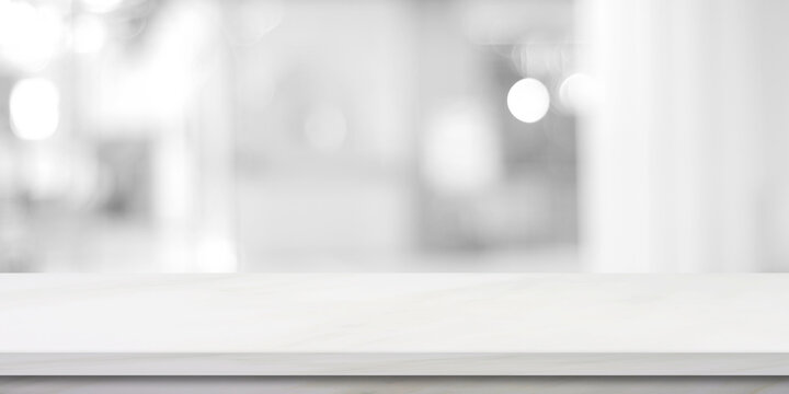 Vertical empty white table top, counter, desk over blur perspective store with bokeh light background, White marble stone table, shelf and blurred shop for food, product display mockup