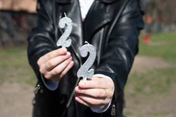 A woman holding birthday numeral candle