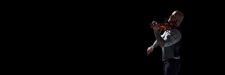 Classical music event. Bald man in formal wear playing violin against blue background. Concept of...