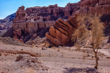 The huge Charyn Canyon in the desert of Kazakhstan. People go down a canyon in the desert among...