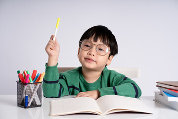 Portrait of an Asian boy studying on a white background
