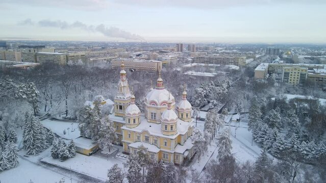Ascension Cathedral in the Park of 28 Panfilovites in Almaty. Old historical building made of wood in the center of Almaty. Popular tourist place in the snow. Aerial photography of the church.