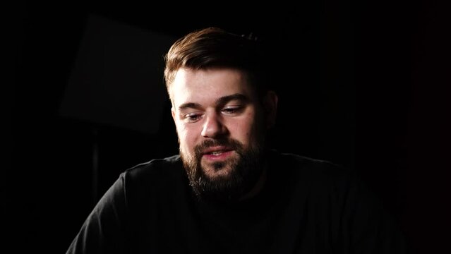 Talking head shot of male in studio type setting with black background