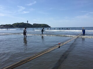 江の島と地引網とサーファー