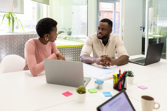 Colleagues discussing work at a bright office space