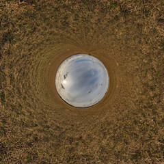 blue hole sphere little planet inside sand or dry grass round frame background