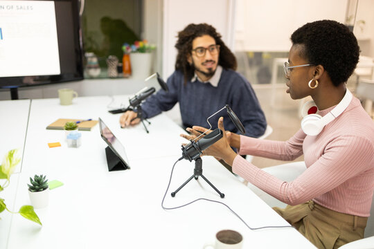 Multiracial team recording podcast in modern office