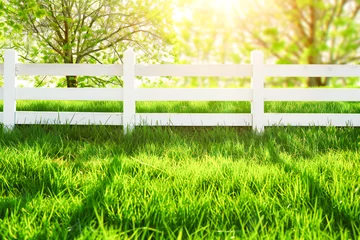 Wandaufkleber White fence on the background of green meadow and nature landscape © VetalStock