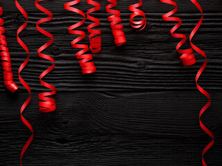 red ribbon for celebration on a black wooden background - 774040992