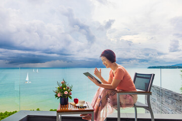 Senior digital nomad woman working at luxury villa in Phuket. andaman sea as background. - 774051585