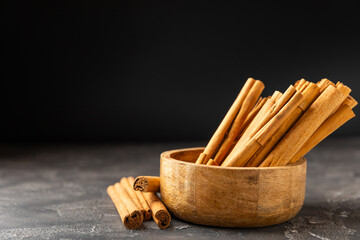 Ceylon cinnamon.Cinnamon sticks on a textured wooden background. Cinnamon roll and powder. Spicy spice for baking, desserts and drinks. Fragrant ground cinnamon. Close-up. Place for text. copy space