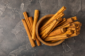 Ceylon cinnamon.Cinnamon sticks on a textured wooden background. Cinnamon roll and powder. Spicy spice for baking, desserts and drinks. Fragrant ground cinnamon. Close-up. Place for text. copy space