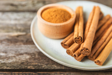 Ceylon cinnamon.Cinnamon sticks on a textured wooden background. Cinnamon roll and powder. Spicy spice for baking, desserts and drinks. Fragrant ground cinnamon. Close-up. Place for text. copy space