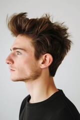 Obraz premium Close-up side portrait of a young man showcasing a detailed spiky hairstyle