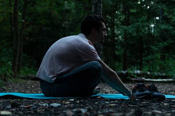 Kissenbezug Young handsome man doing yoga in lotus position in the wood. Training and sport on nature concept  © Vitaliy