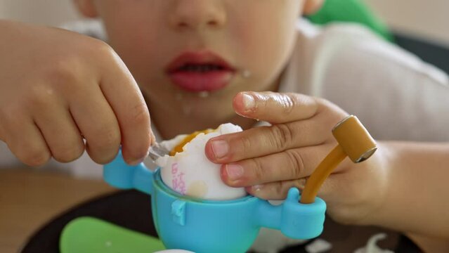 Little Boy Eats Soft-Boiled Egg In Fun And Childish Egg Holder