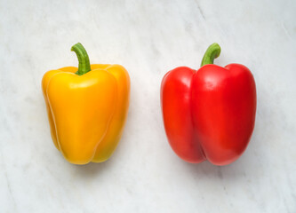 Red and yellow peppers on white marble background, Bell pepper top view