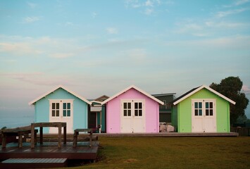 Row of cute colorful beach huts against blue cloudy sunset sky in New Zealand